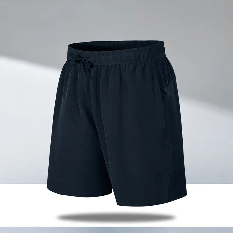 Man wearing loose-fit black quick-drying polyester beach shorts with a micro-elastic waistband.