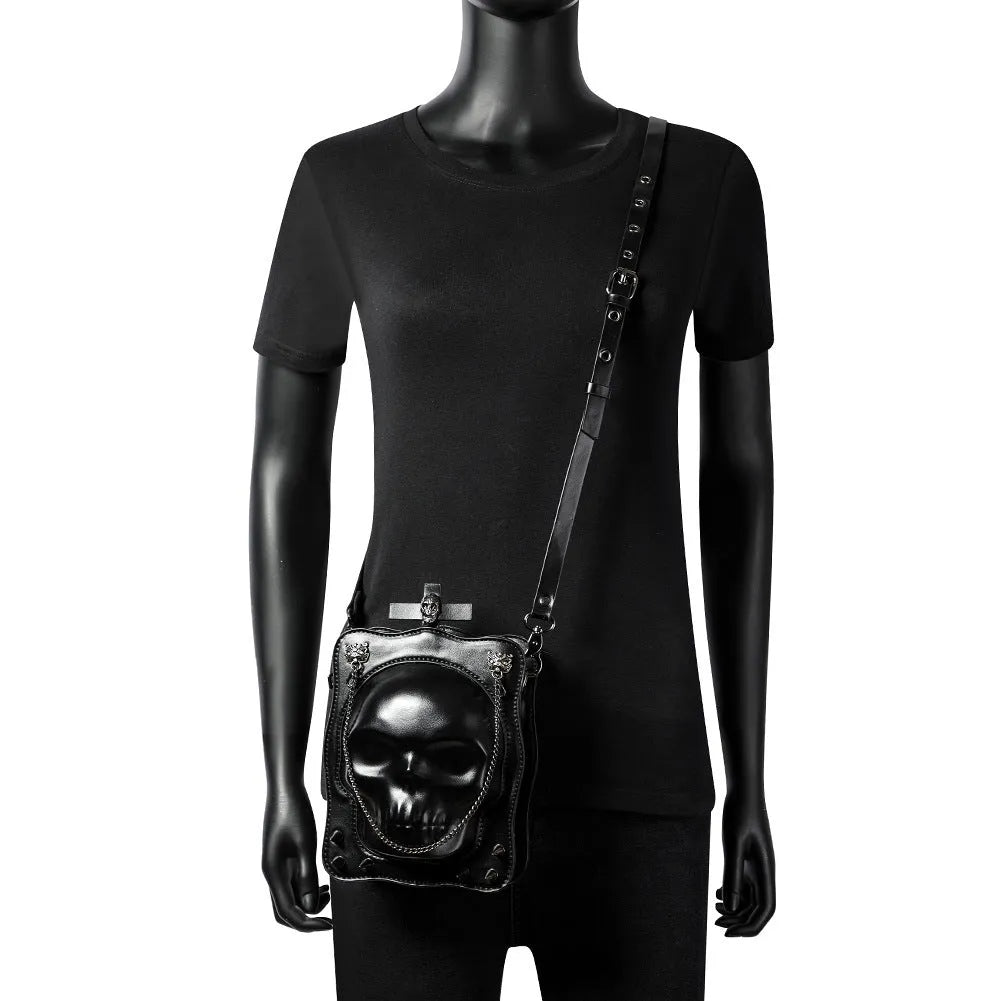 Black mini square crossbody bag with skull embroidery, decorative stitching, and metal chain details