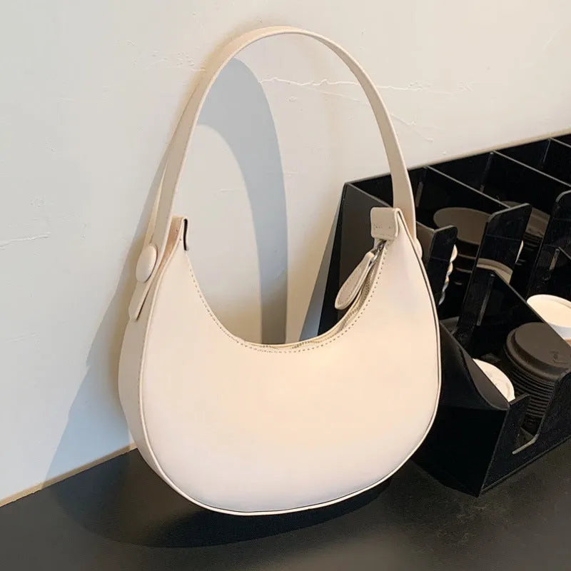 Women's retro-style PU shoulder bag in a dumpling shape, shown in one of four colours: black, cream yellow, brown, or white.