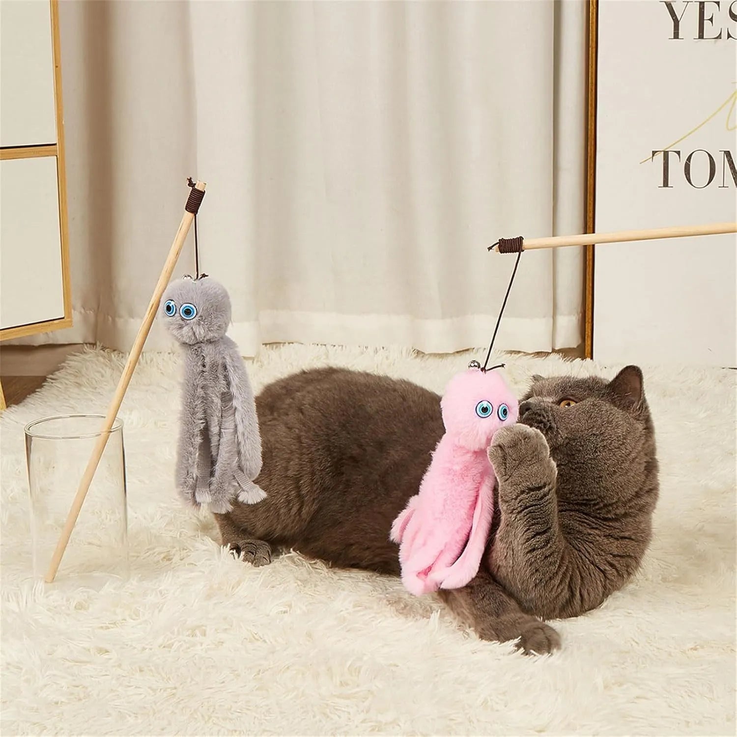 Grey furry octopus cat toy with eyes on a long stick for interactive indoor play with kittens.
