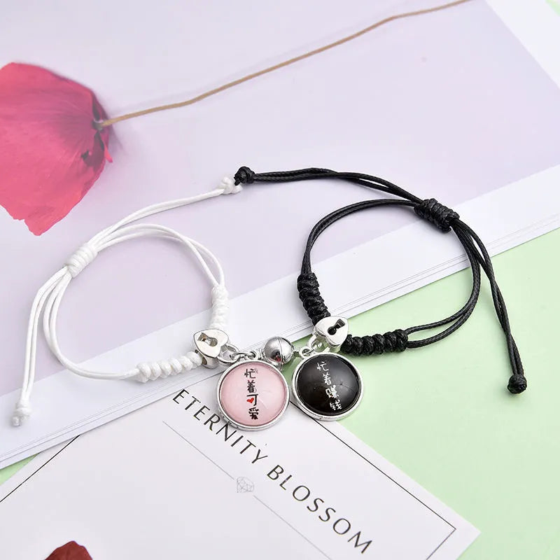 Pair of magnetic suction bracelets with alloy charms in various love and friendship themed designs on a wrist.