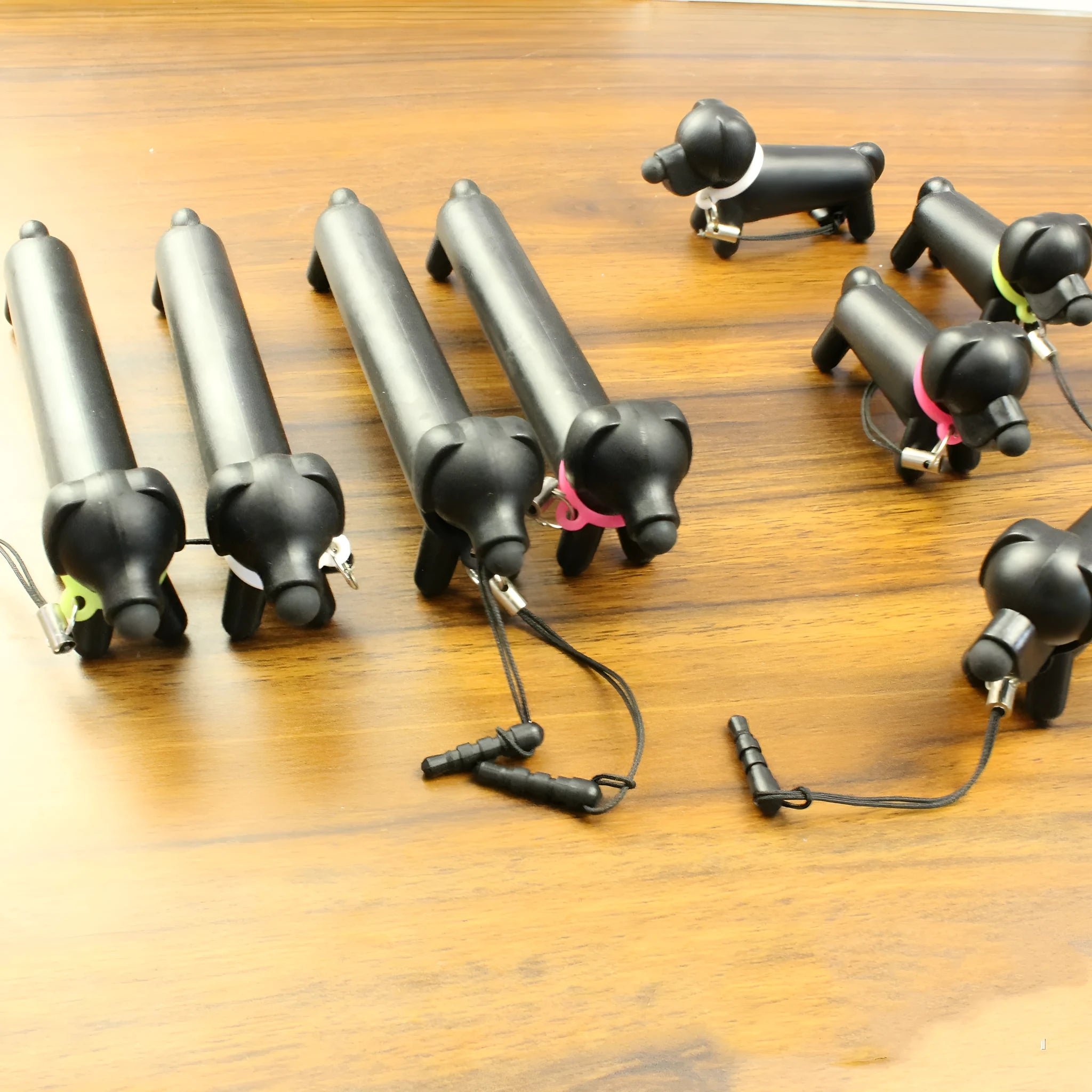 Black dog-shaped touch screen stylus showing length adjustment and phone holder function