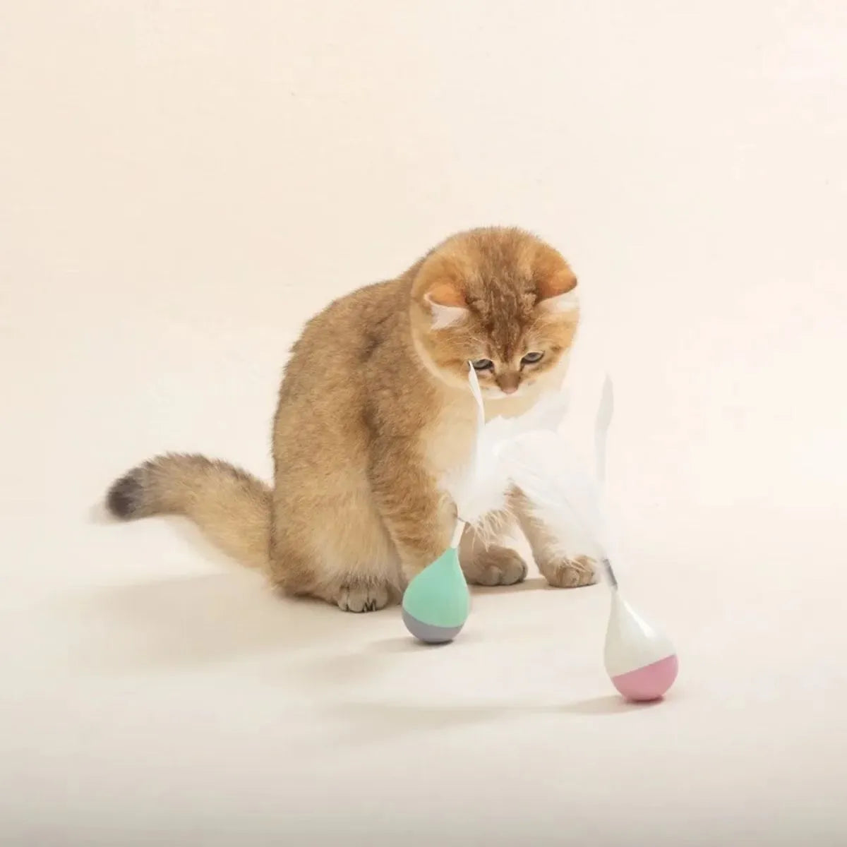 Feather Tumbler Cat Toy with goose feathers and aluminium alloy construction on pink background