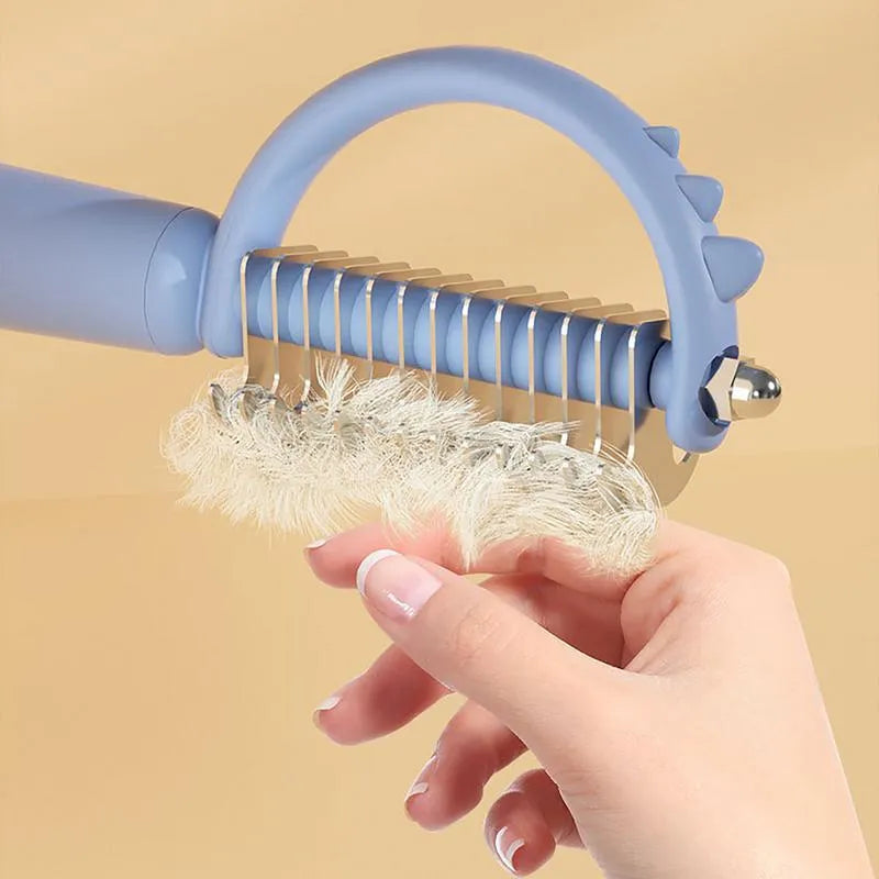 Blue dinosaur-shaped cat brush with self-cleaning feature and double-sided grooming heads