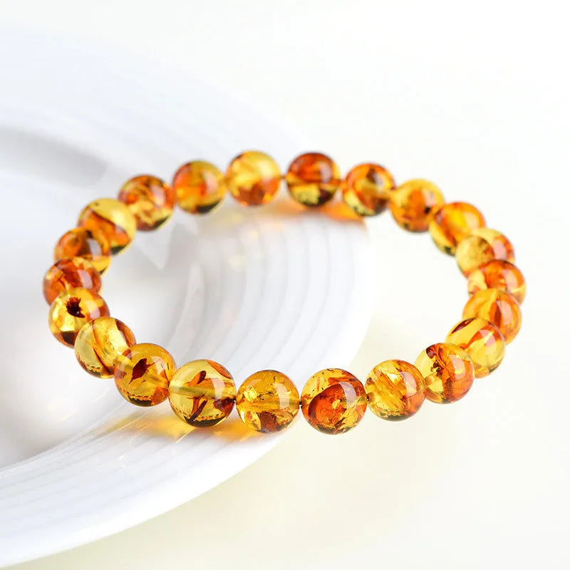 Yellow piebald amber bracelet with geometric beads showing natural flower spot patterning