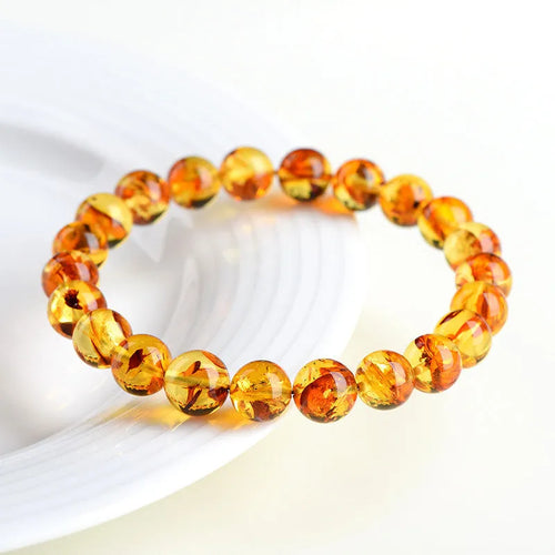 Yellow piebald amber bracelet with geometric beads showing natural flower spot patterning