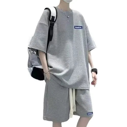 Man wearing a grey waffle-textured short sleeve top and matching shorts leisure set.