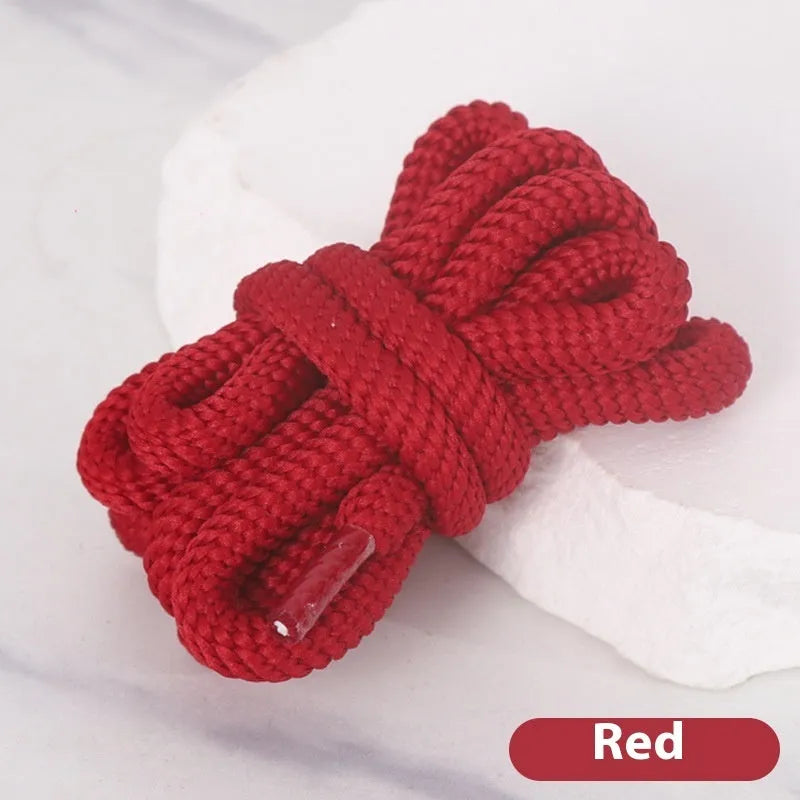 Oval cross-section shoelace adapter rope in various colours, shown next to a trainer and sweatshirt.