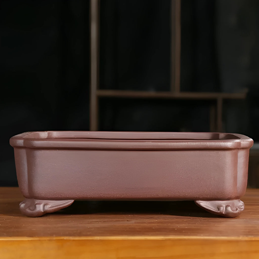 Rectangular antique purple sand bonsai planter with corner-cut design on floor.