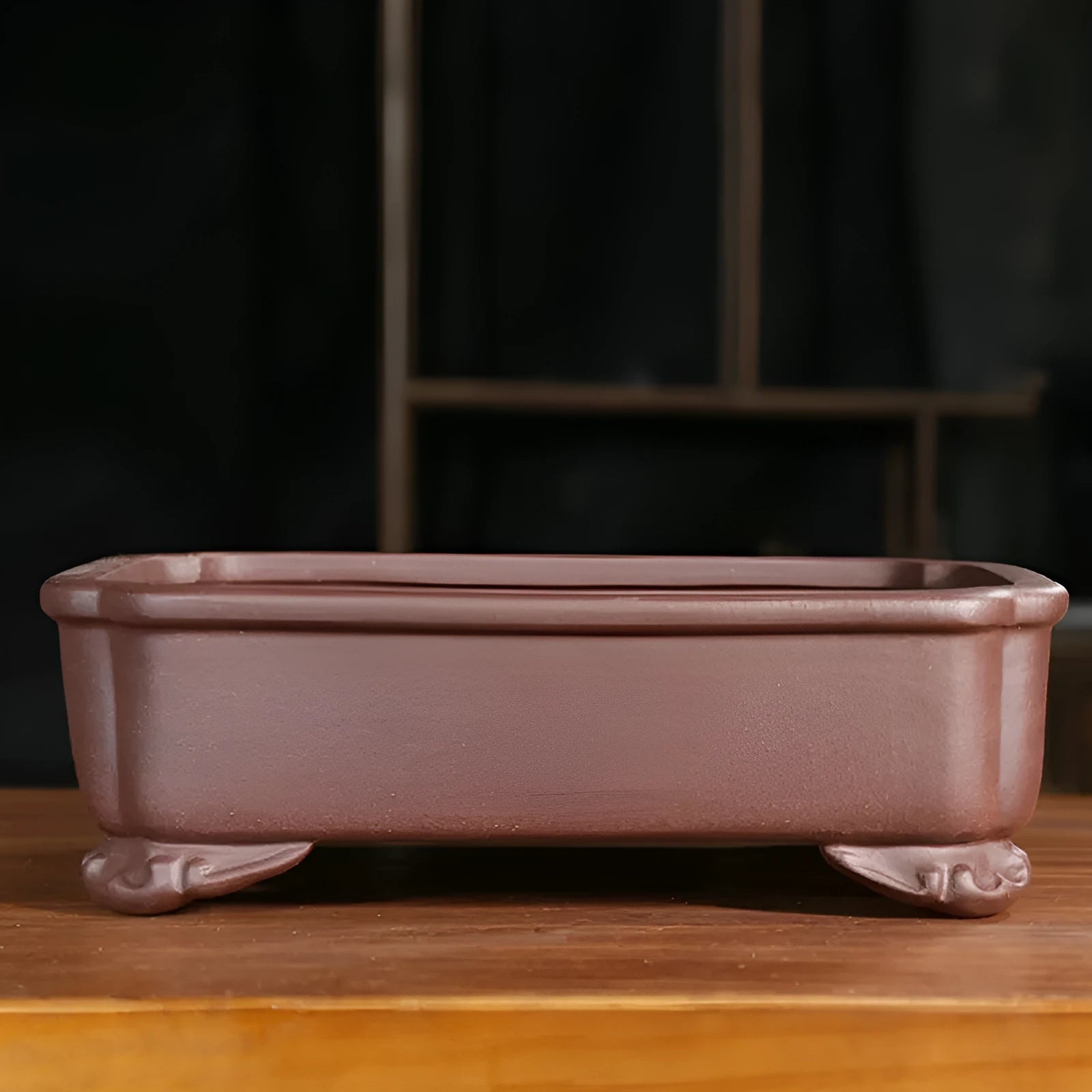 Rectangular antique purple sand bonsai planter with corner-cut design on floor.