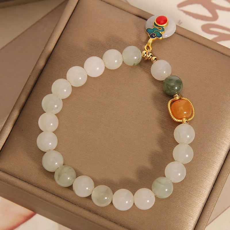 Close-up of a women's ice jade bracelet with a peace jade buckle and pearl decorative elements.