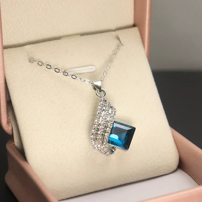 Glass pendant on an alloy cross chain necklace with matching ear studs, in two colour style options.