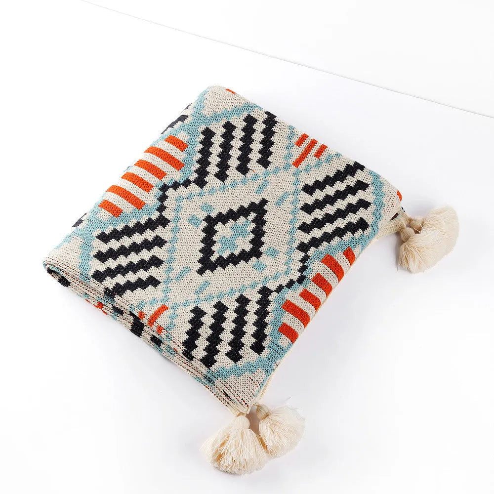 Acrylic sofa blanket with tassel fringe in geometric pattern, showing 130 cm width measurement