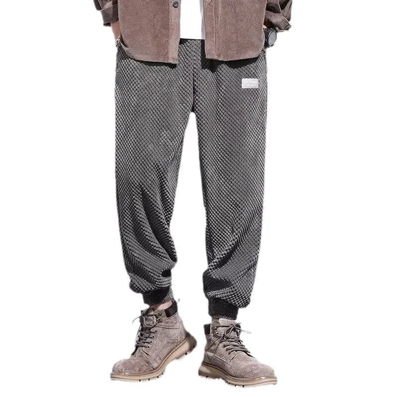 Men's grey ankle-tied straight leg sweatpants laid flat on a surface.