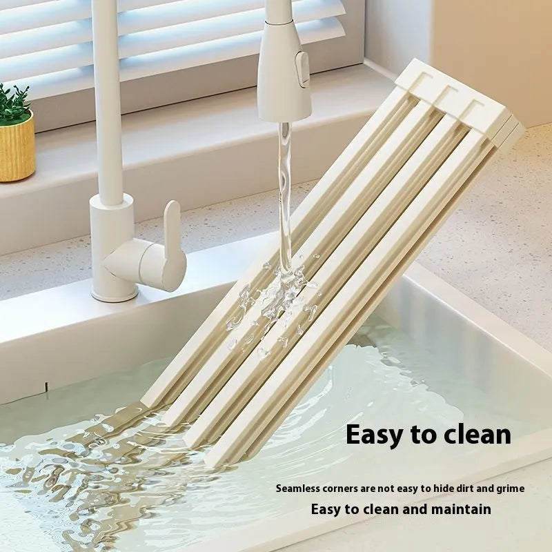 Milky white foldable stainless steel kitchen draining rack shown over a sink.