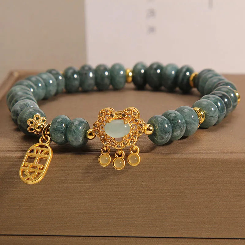 Close-up of a women's bracelet with emerald green jade abacus beads and a metallic safety lock clasp.