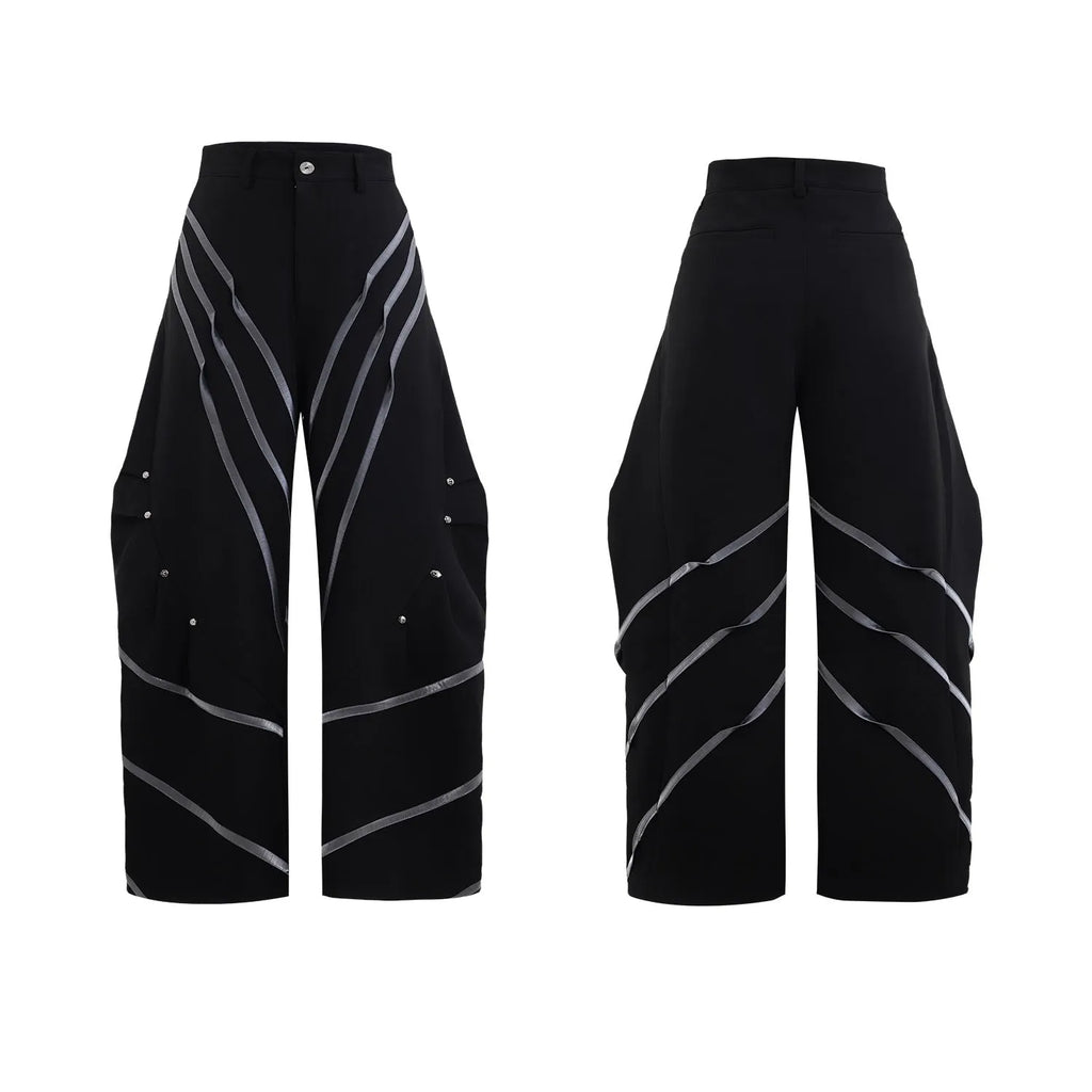 Men's black trousers with three-dimensional cut and silver metal rivet pleat detailing.