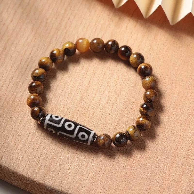 Single Tigereye Dzi bead Buddha rosary bracelet on wrist, showing simple ethnic design.