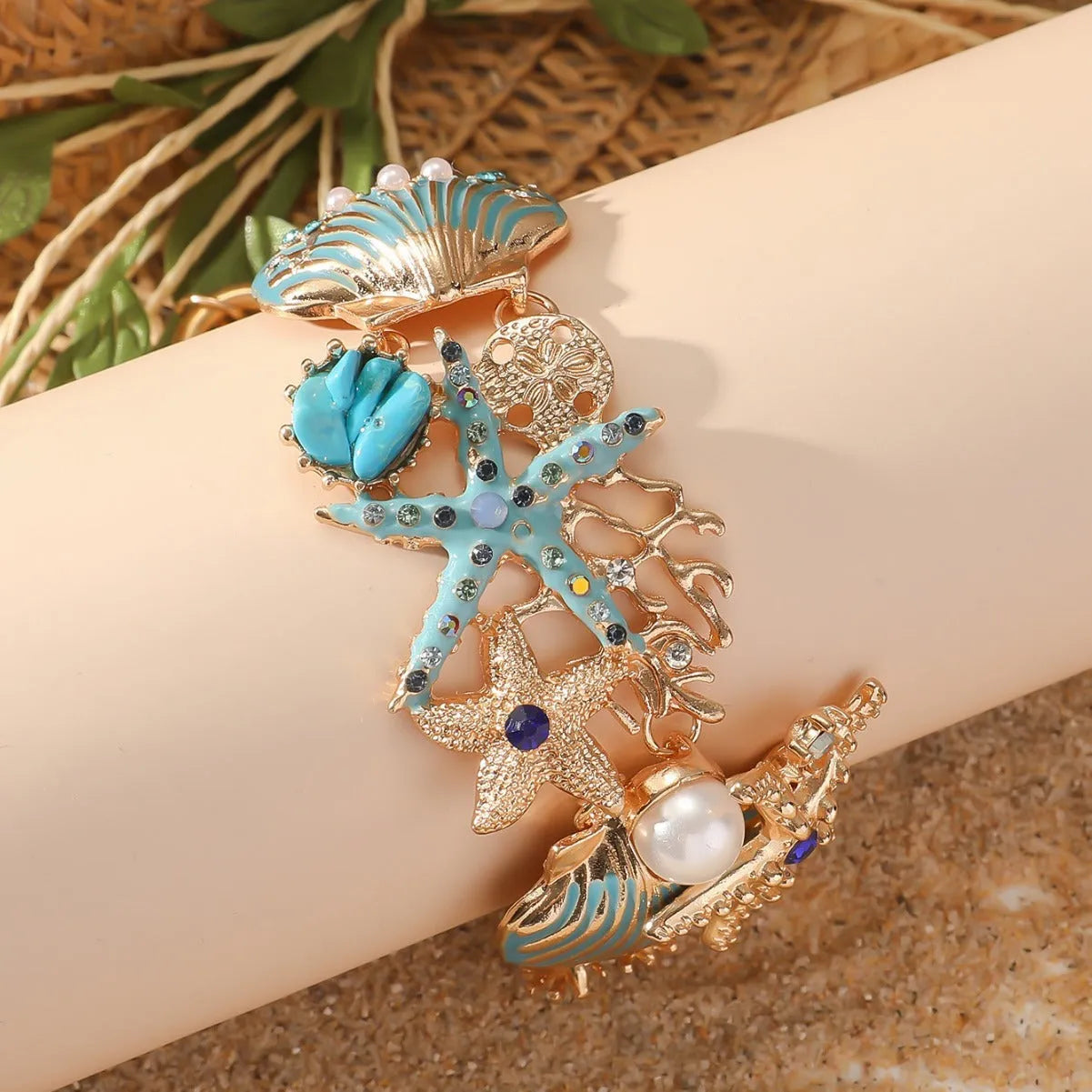 Women's alloy rhinestone bracelet with a nautical boat anchor and starfish design in blue coral colour.