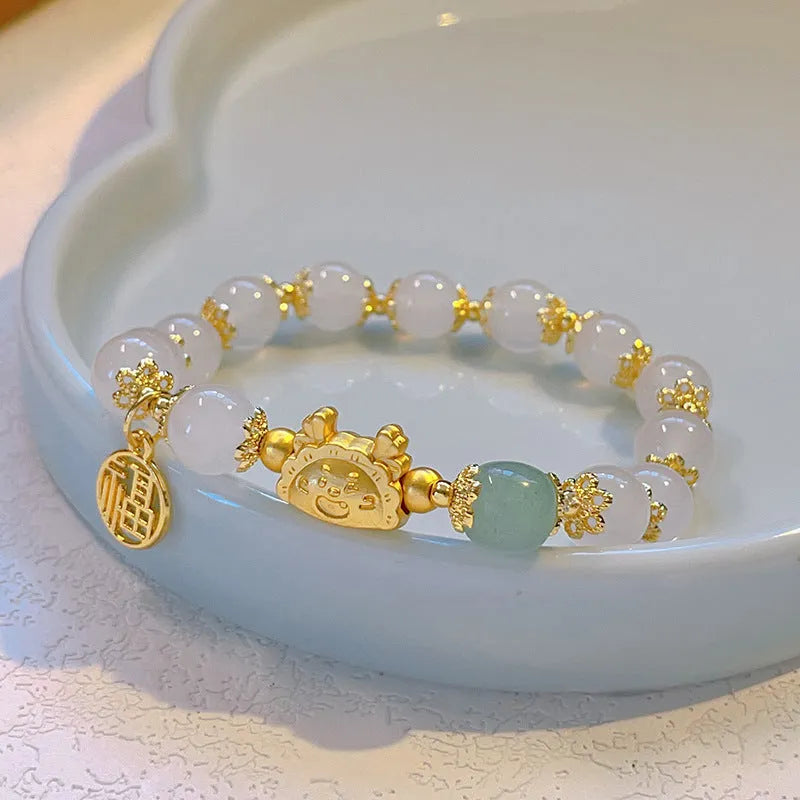 Women's floral glazed bracelet with ice crack texture and zodiac animal charm on wrist.