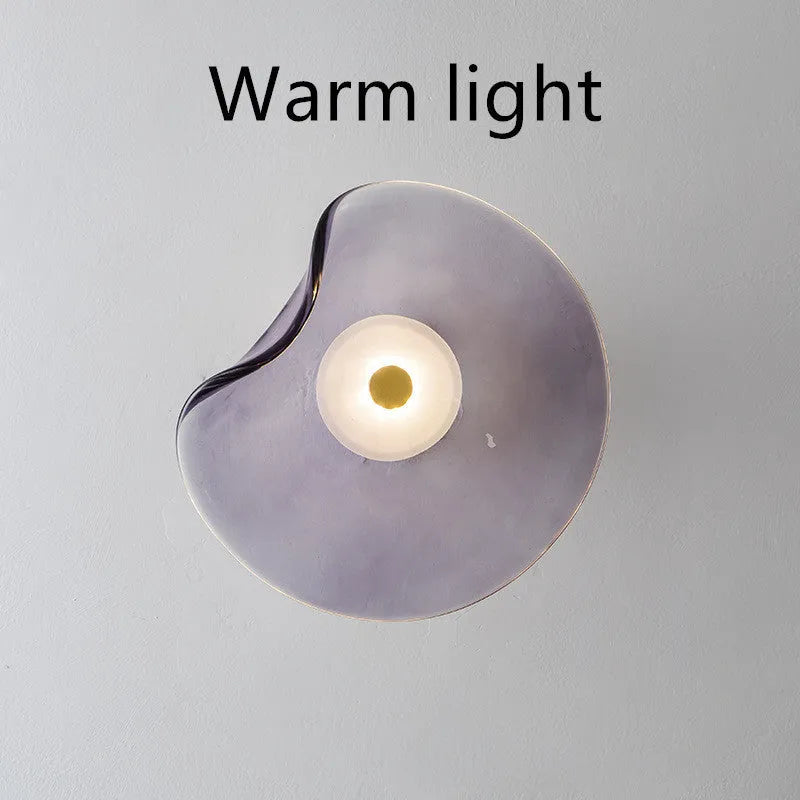 Round glass bedside wall lamp in cognac, light purple, or smoky grey colour.
