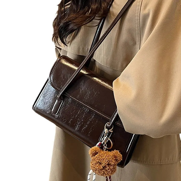 Brown women's Maillard-style PU leather shoulder bag with a double strap and a removable pendant accessory.