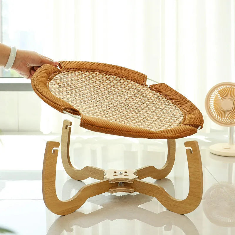 Brown square woven rattan raised hammock bed for cats and dogs on a wooden floor.