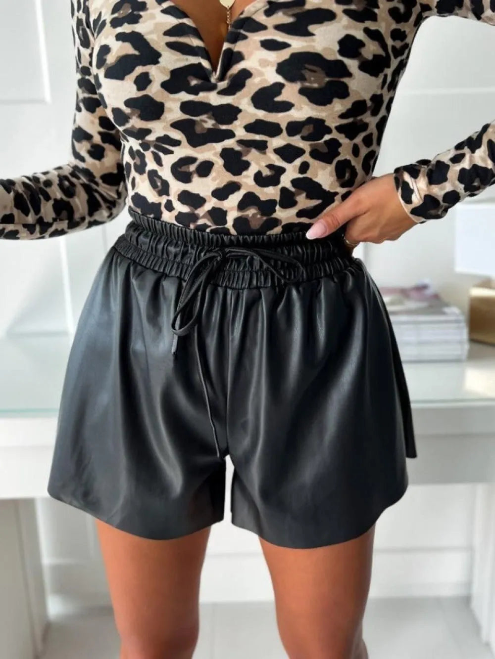 Women's black drawstring lace-up PU leather wide-leg casual shorts on a hanger.