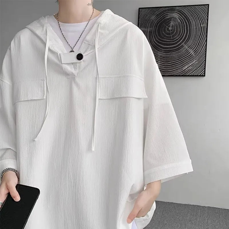 A man wearing a loose-fit black hooded short sleeve t-shirt made of polyester for summer.