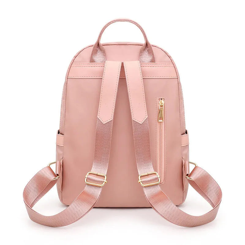 Women's casual nylon backpack in black or pink with square shape, showing external pocket and double straps.