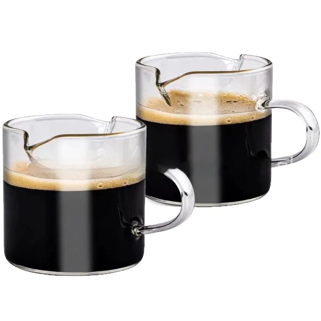 Two white transparent double mouth coffee glasses on a table.