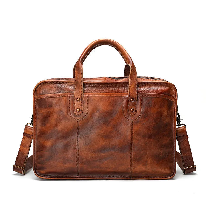 Black vintage leather men's briefcase open to show internal laptop pocket, camera pocket, and document organisation.