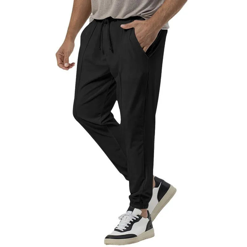 Men's loose tapered casual track sweatpants in cotton blend fabric showing straight-leg design