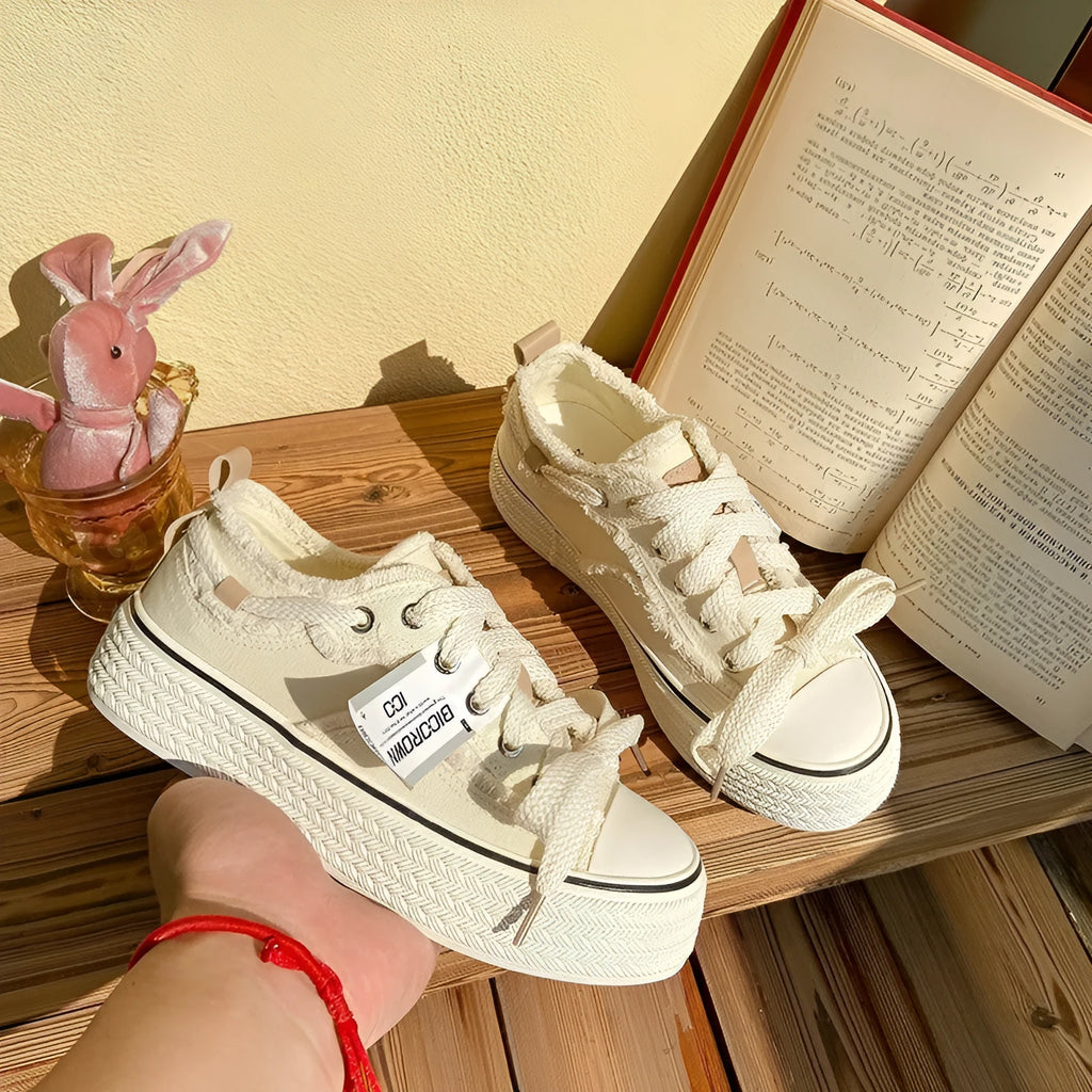 Women's low-top canvas shoes in solid colour with vulcanised rubber sole, available in beige, black, and pink.