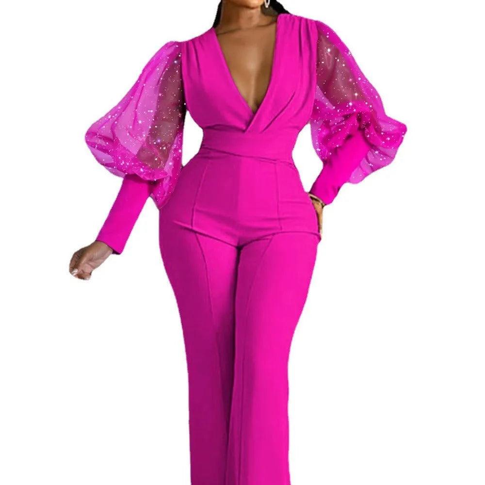 Red women's jumpsuit with mesh stitching on long sleeves, slim fit bodice, wide legs, and elastic waist.