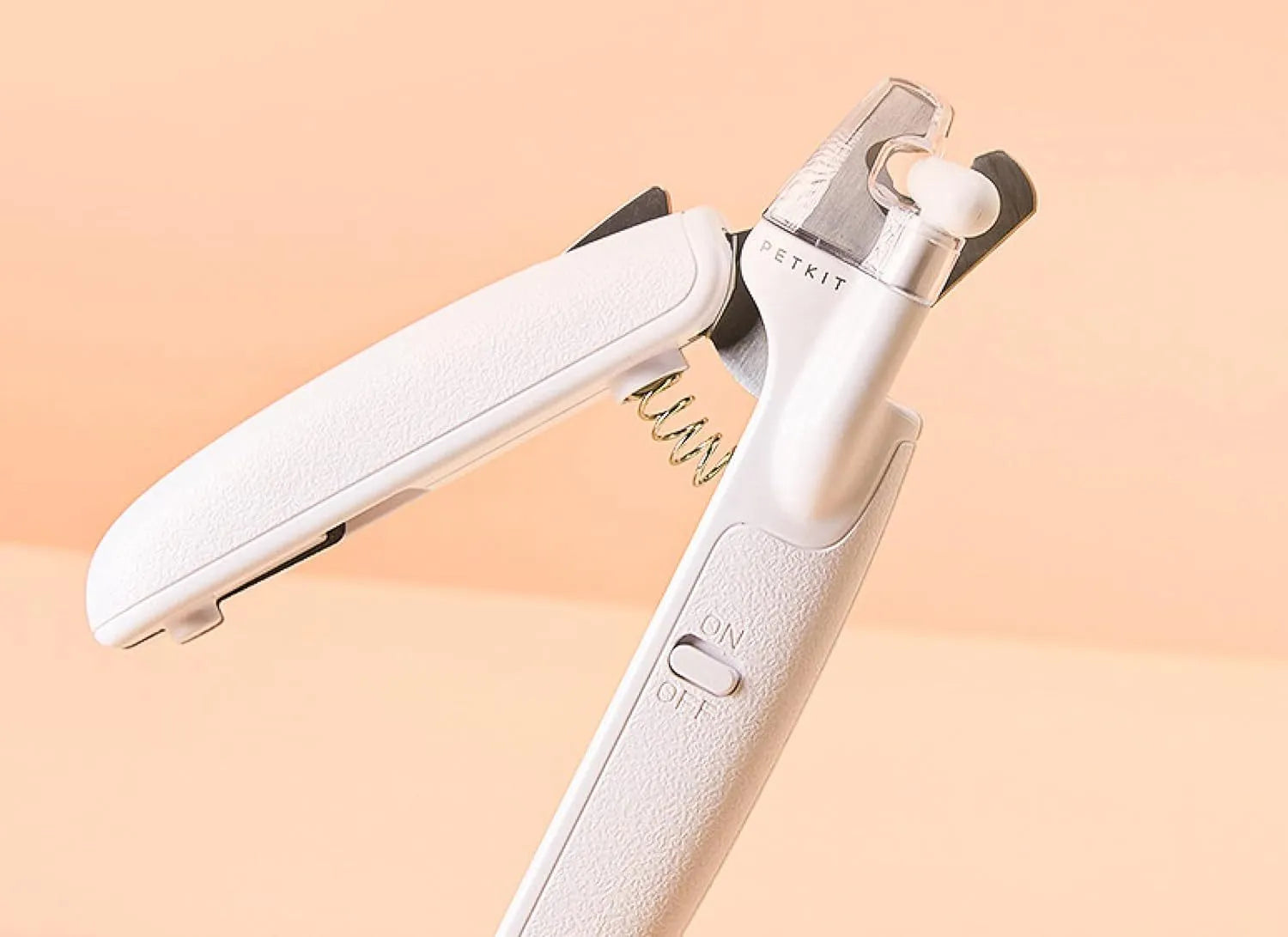 White pet nail clippers with LED light and a transparent anti-splash guard, shown with a nail file.