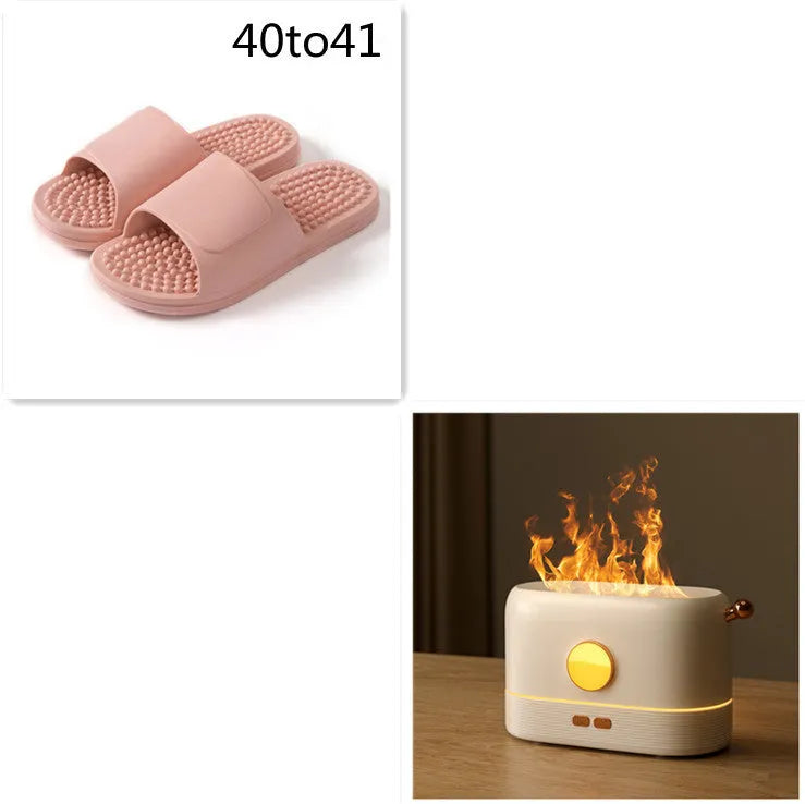 Black USB desktop humidifier with decorative orange flame effect and water tank on a wooden desk.