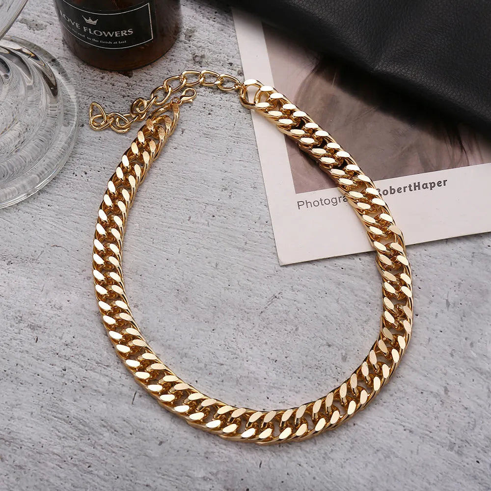 Women's gold thick chain necklace with a pendant on a model, showing its 32cm length.