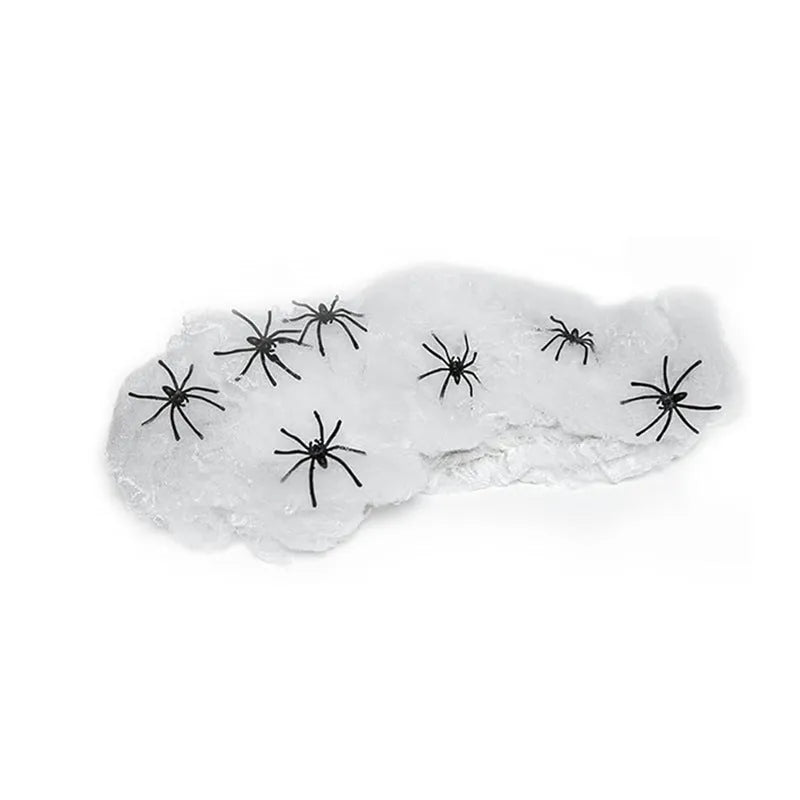 White cotton spider web Halloween decoration with plastic spiders draped over furniture