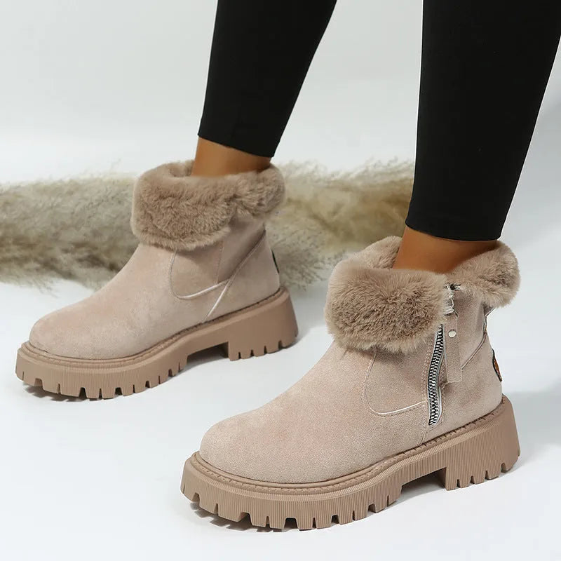 Women's black snow boots with foldable plush tube, suede upper, and rubber sole on winter pavement
