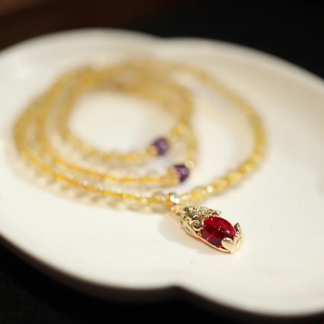 Handmade gold and ruby quartz Chinese bracelet with three circles and hanging chopstick detailing