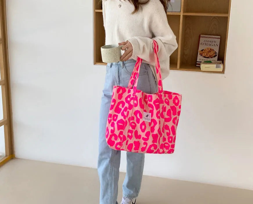 Pink Oxford cloth women's shoulder bag with a large main compartment and a black three-dimensional front pocket.