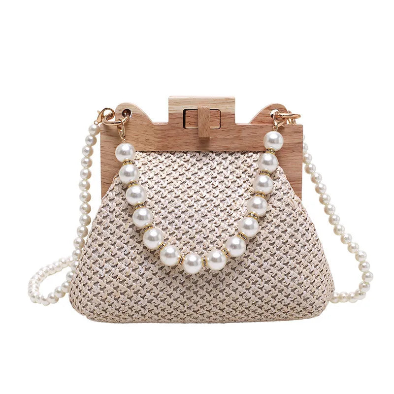 Women's woven straw shoulder bag with pearl chain strap in horizontal square shape showing sandwich pocket detail.