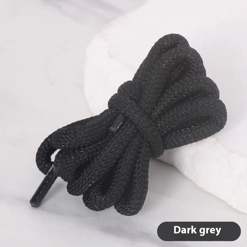 Oval cross-section shoelace adapter rope in various colours, shown next to a trainer and sweatshirt.