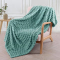 Soft camel-coloured plaid fleece blanket for children folded on a bed.