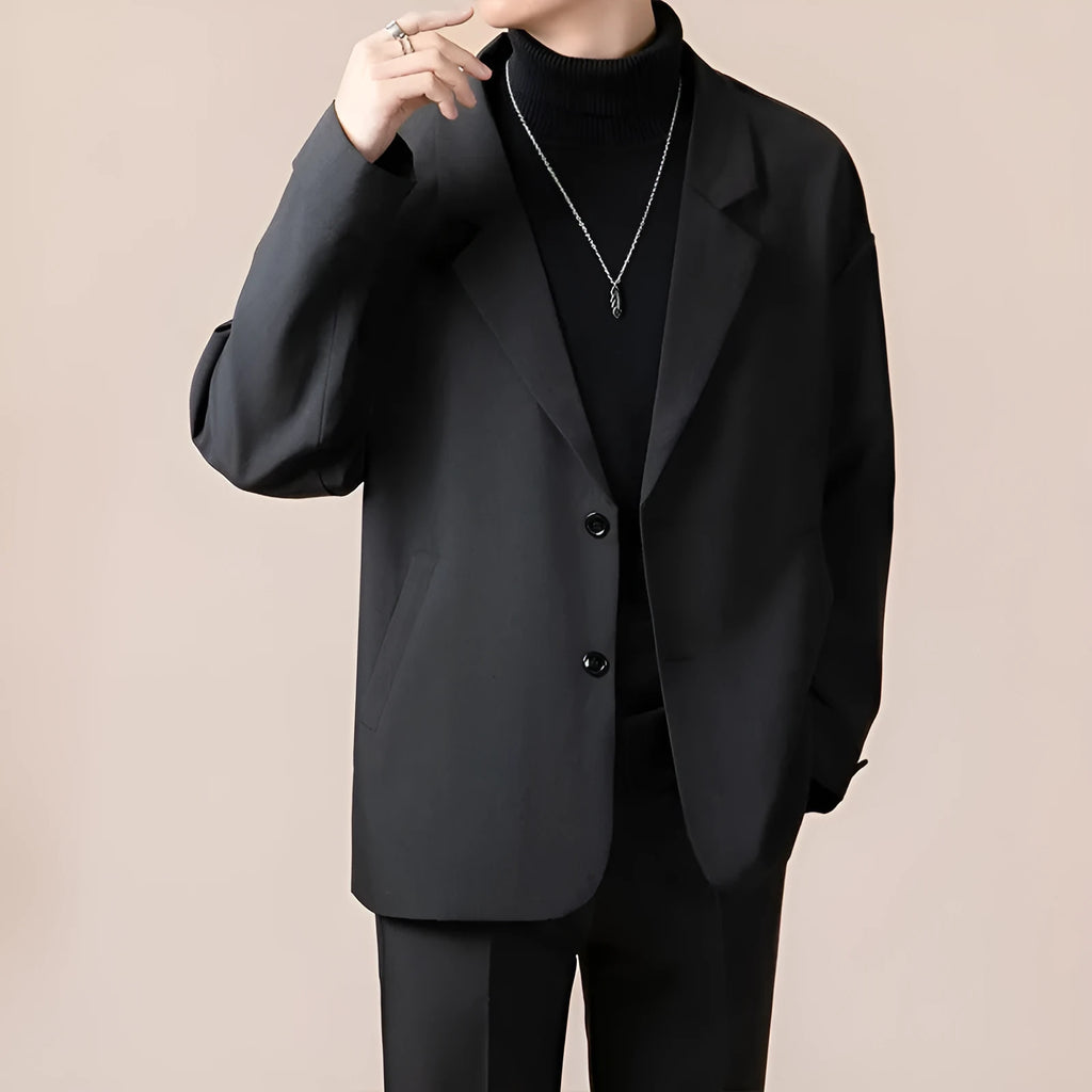 A man's loose fit suit jacket in a chemical fibre blend fabric, shown in one of four available colours.