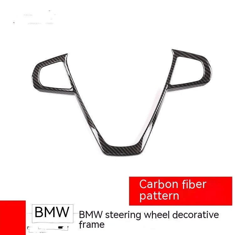 BMW steering wheel button frame decorative trim in black carbon fibre pattern.