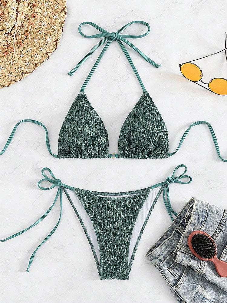 Green and pink women's backless halter swimsuit top and shorts set on a white background