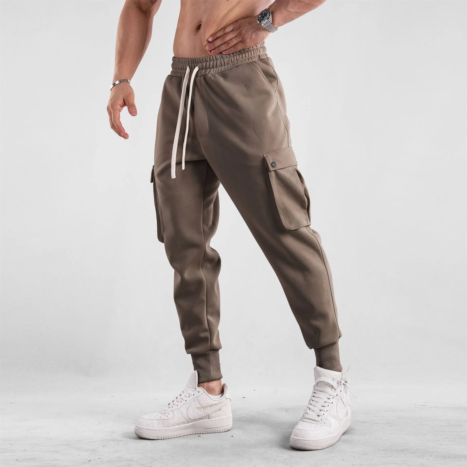 Men's loose-fit light grey cotton sports trousers with ankle tie and side pockets.