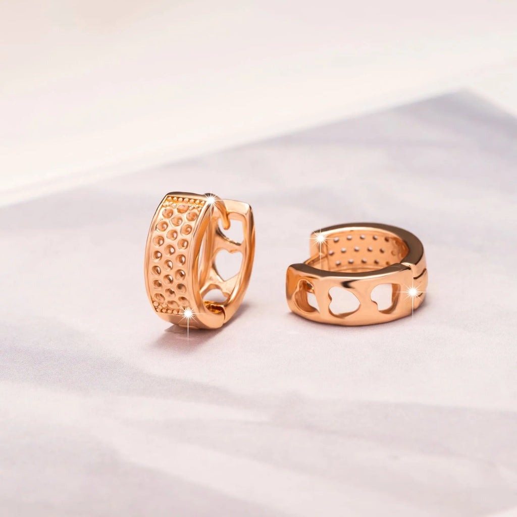 Rose gold women's earrings with hollowed out heart design in circular frame